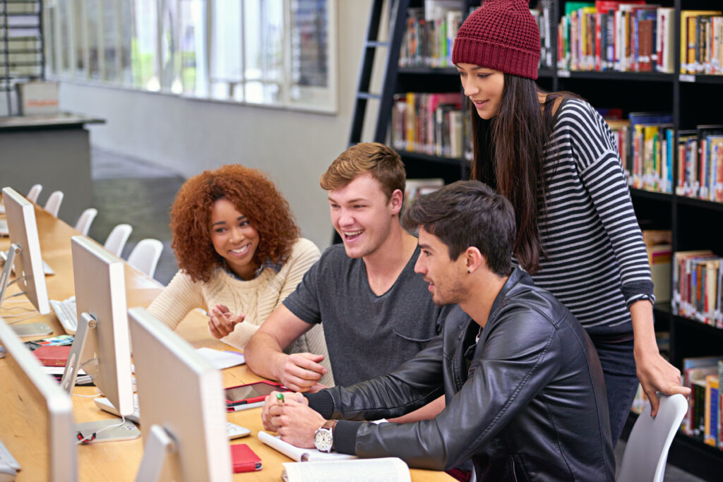 Students unite. students working on computers in a university library.